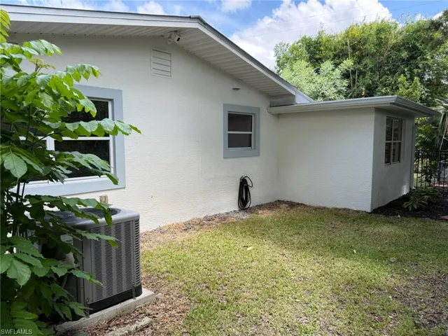 Side view of home's exterior with the 2022 HVAC unit, and fenced backyard