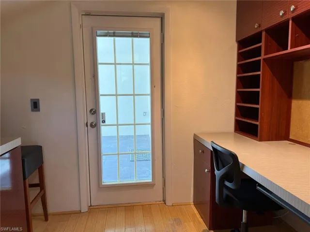 Office area with built in study area, plenty of natural light, and light wood flooring