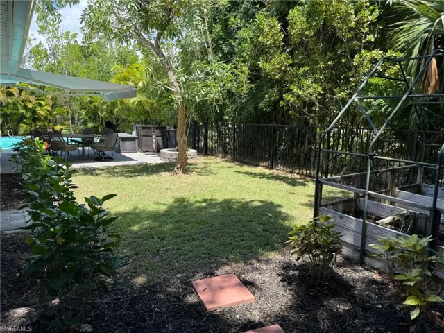 Fenced backyard with a patio area under morotized awning
