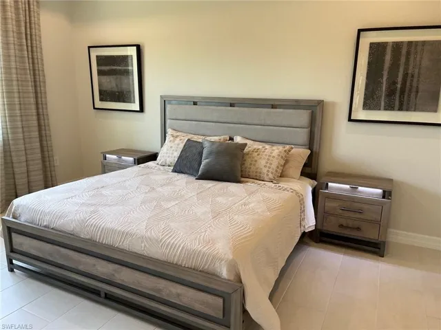 Bedroom featuring light tile patterned flooring and baseboards