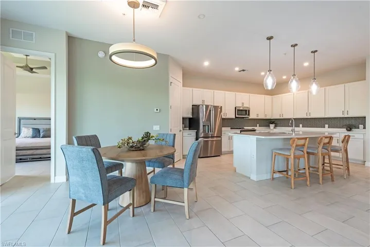 Kitchen with decorative backsplash, visible vents, a sink, and appliances with stainless steel finishes