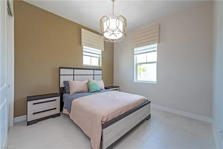 2nd Bedroom featuring light tile patterned floors, baseboards, and an inviting chandelier