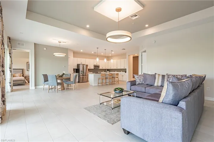 Living area with recessed lighting, a raised ceiling, and visible vents