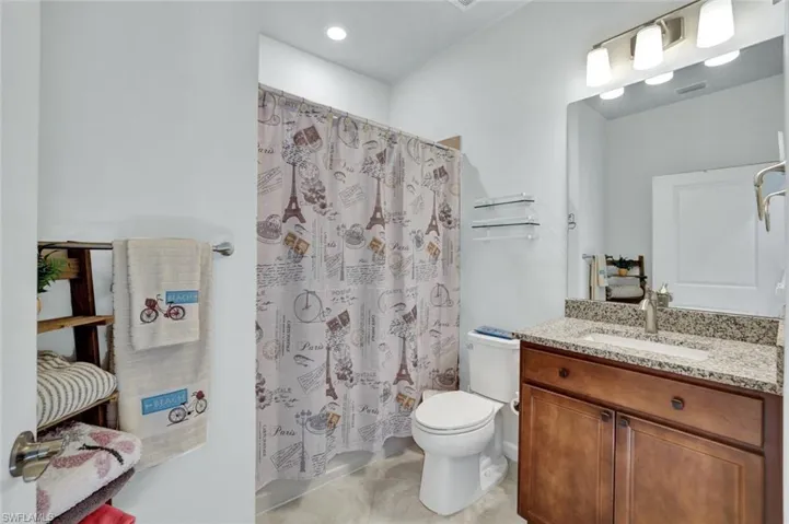 Bathroom featuring vanity, toilet and tile floors