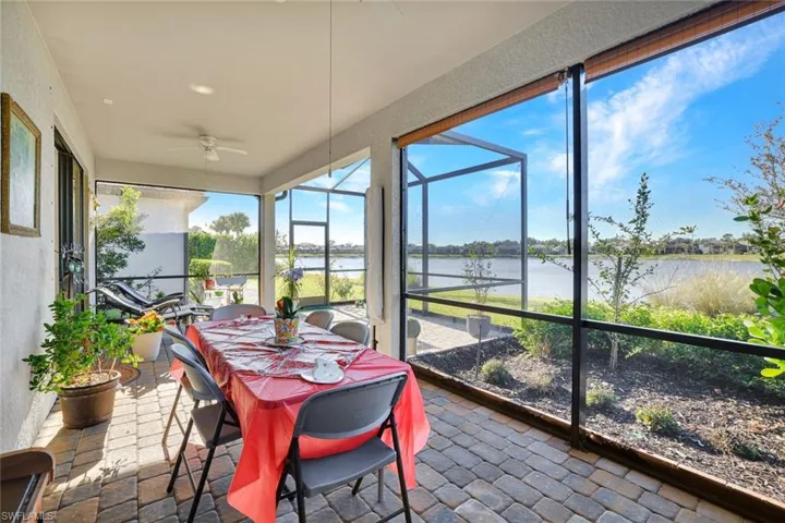 Sunroom / solarium with ceiling fan, a water view and outdoor dining space