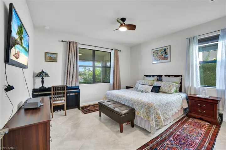 Bedroom with ceiling fan and light tile patterned floors