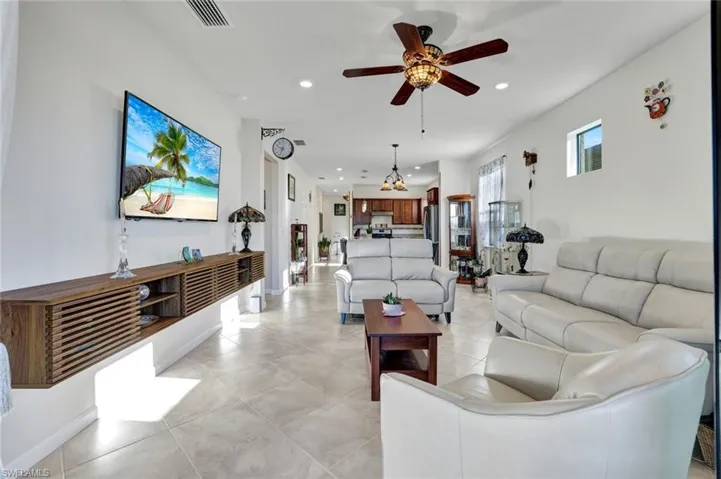 Living room featuring recessed lighting, a ceiling fan, and light tile patterned floors