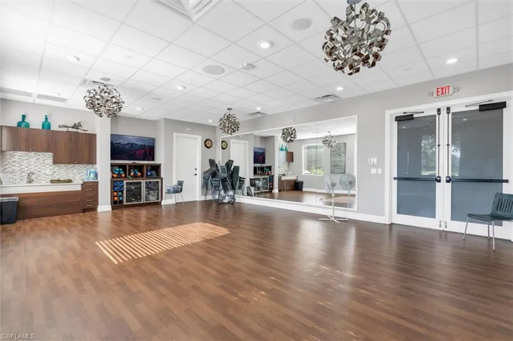 Workout area featuring hardwood / wood-style floors, a drop ceiling, and sink