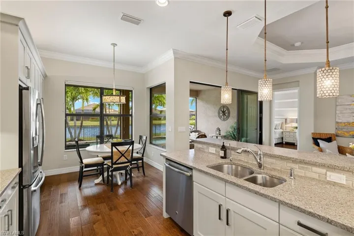 Kitchen featuring decorator pendant light fixtures, white cabinetry, sink, and appliances with stainless steel finishes