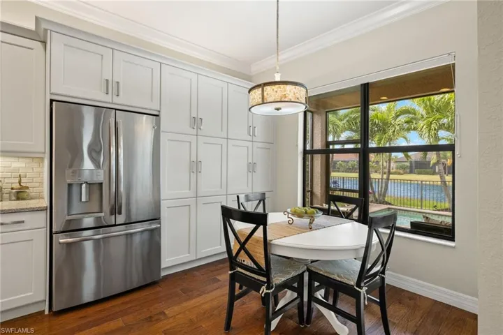 Brkfst room featuring dark hardwood flooring, upgraded wall of cabinets and ornamental molding