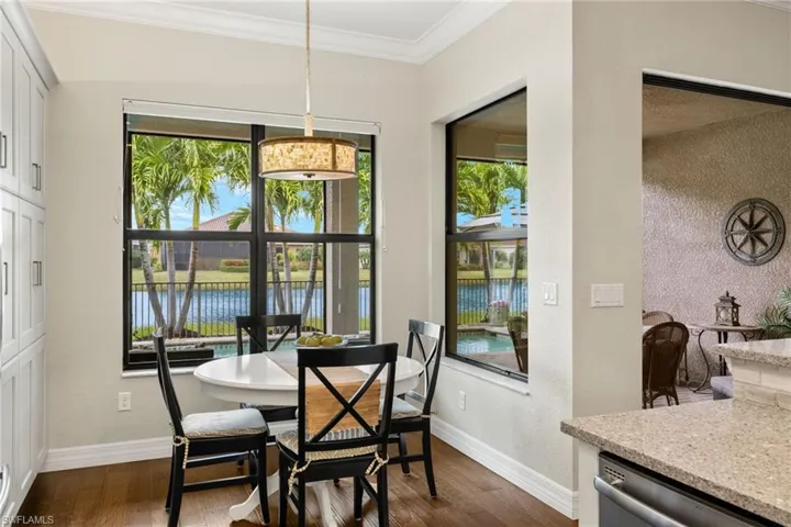 Sunny and bright Brkfst area featuring a water view, dark hardwood  floors, and ornamental molding