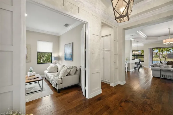 Breathtaking Foyer with designer walls, engineered hardwood floors, 12 foot ceiling with crown moulding, decorator lighting and gorgeous view of pool