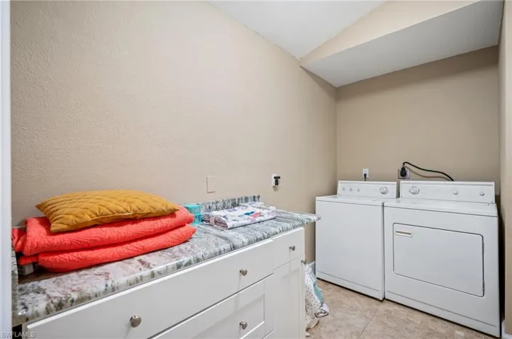 Laundry room with separate washer and dryer and cabinet space