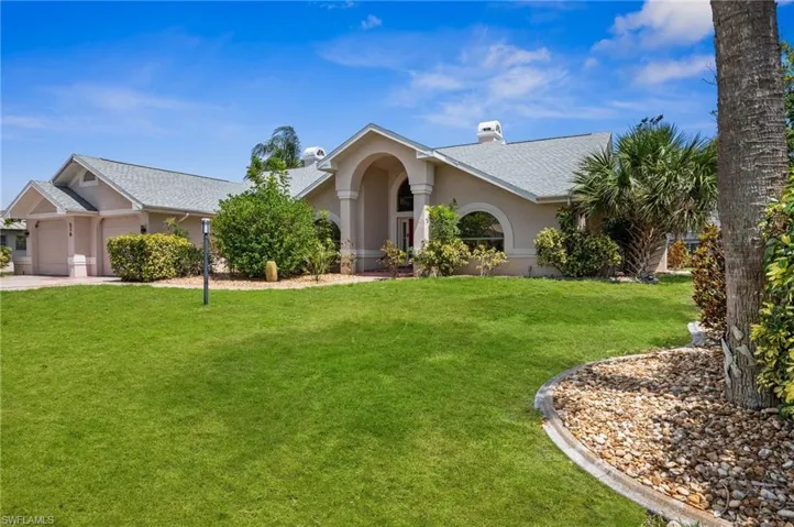 View of front of property featuring an attached garage, stucco siding, a front lawn, a chimney, and concrete driveway