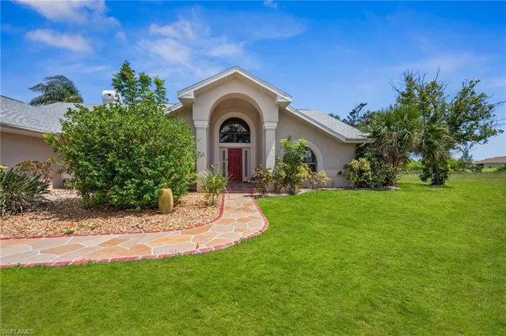 View of front facade with stucco siding and a front yard