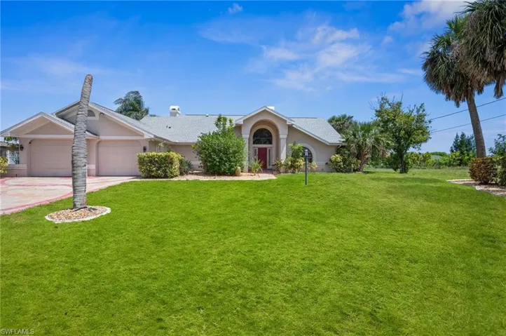 Ranch-style house with stucco siding, a garage, a front lawn, and concrete driveway