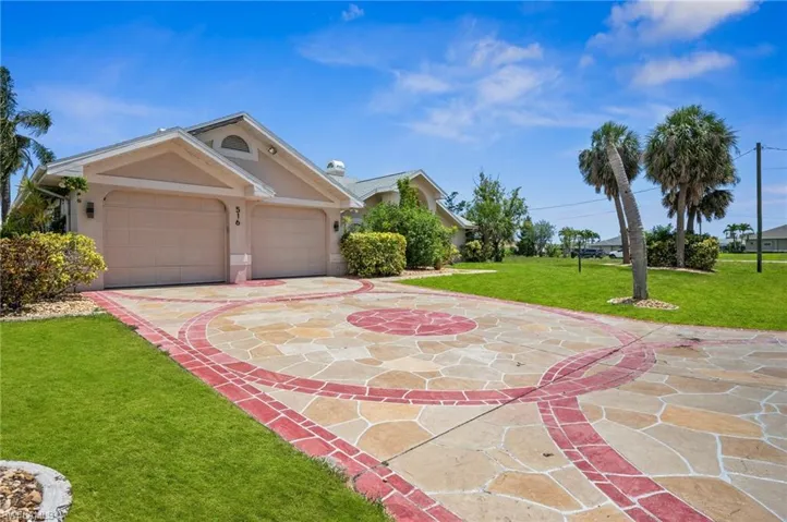 View of front of house with stucco siding, a front lawn, concrete driveway, and an attached garage