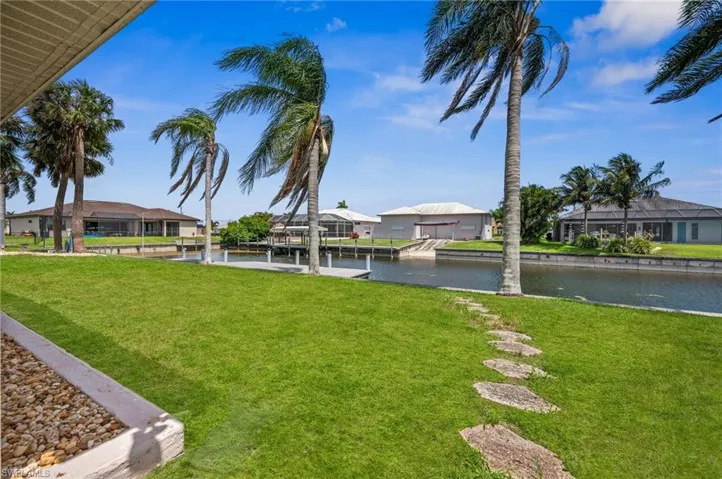 View of green lawn featuring a residential view and a water view