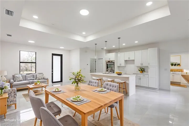 Tiled dining room with a raised ceiling