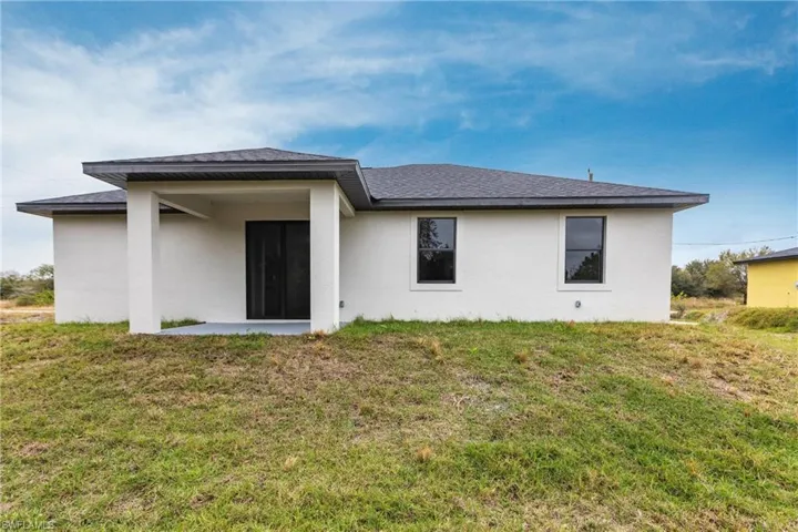 Rear view of property with a lawn