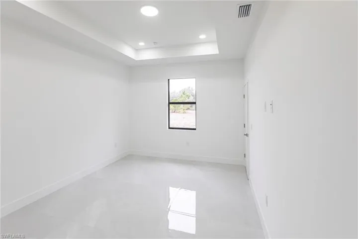 Unfurnished room with a tray ceiling