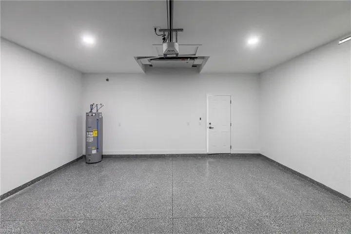 Garage featuring water heater and a garage door opener