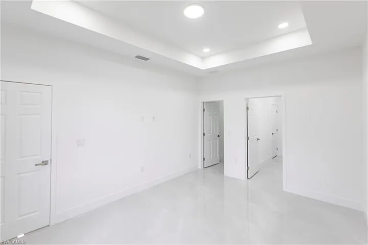Unfurnished room with a raised ceiling