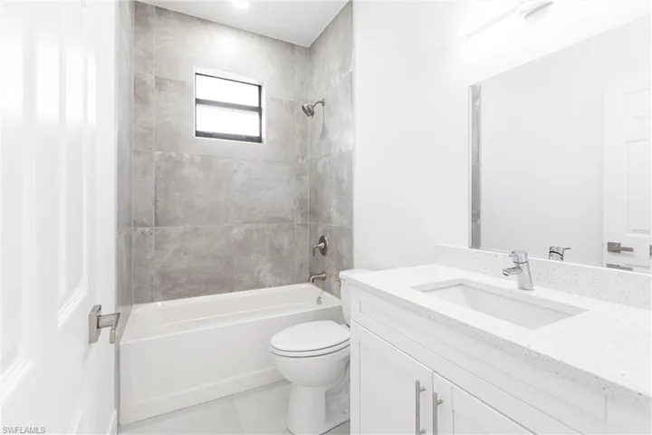 Full bathroom featuring vanity, toilet, tile patterned floors, and tiled shower / bath combo