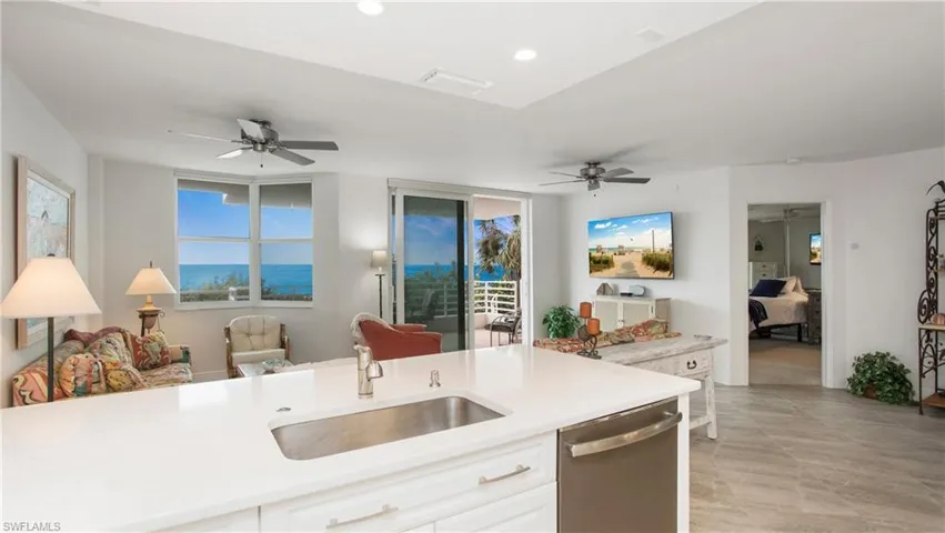 Kitchen with white cabinetry, sink, stainless steel dishwasher, and ceiling fan