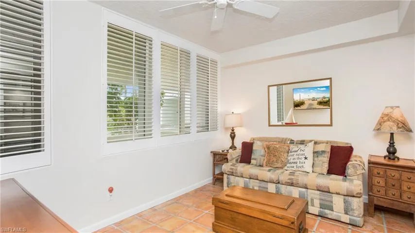 Tiled living room featuring ceiling fan and a textured ceiling