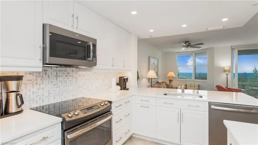 Kitchen featuring stainless steel appliances, sink, white cabinets, and kitchen peninsula