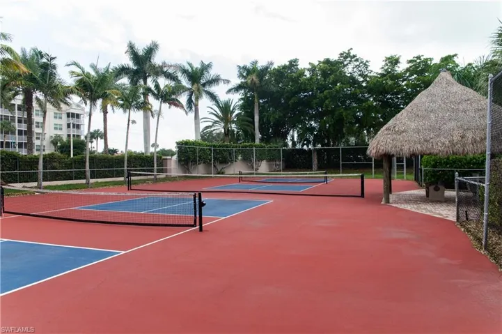 View of tennis court featuring a gazebo and basketball hoop
