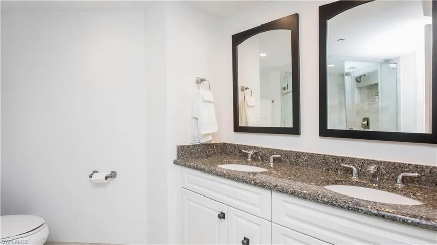 Bathroom with vanity, toilet, and an enclosed shower