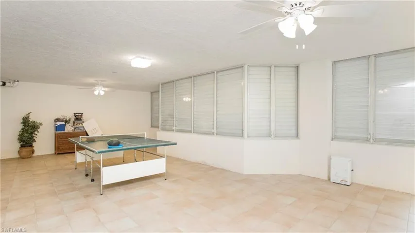Game room with ceiling fan and a textured ceiling