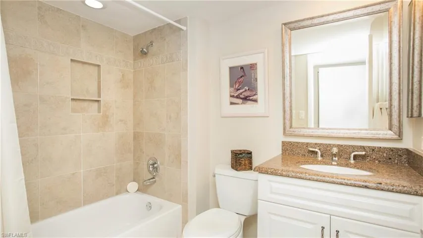 Full bathroom with vanity, shower / bath combination with curtain, and toilet