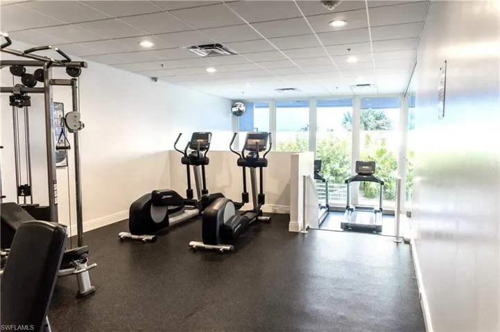 Gym featuring expansive windows and a drop ceiling