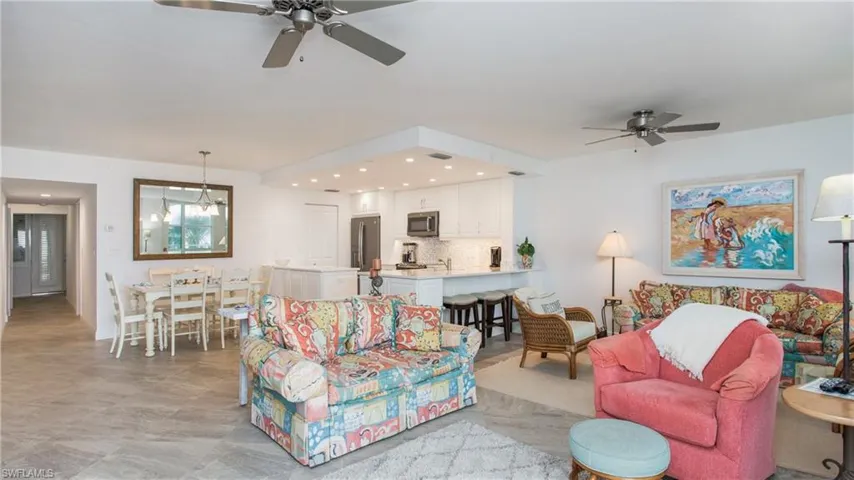 Living room with ceiling fan with notable chandelier