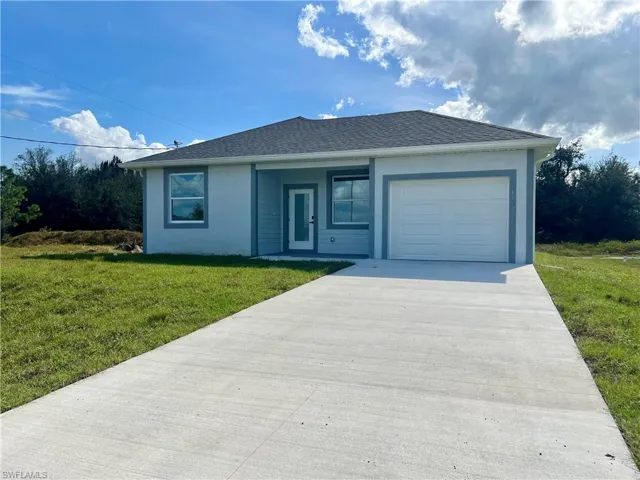 Front of home with a garage, front yard and an extra long driveway with plenty of parking.