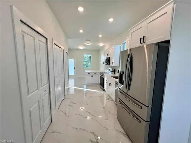Kitchen with white cabinetry and stainless steel appliances