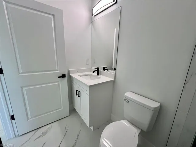 Primary Bathroom with vanity and toilet and QUARTZ tops