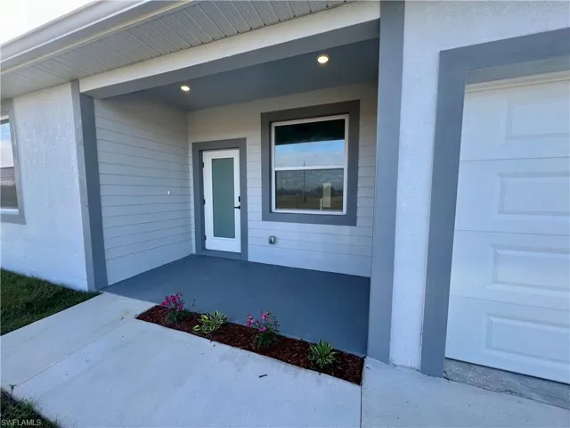 View of exterior entry with a covered front porch.