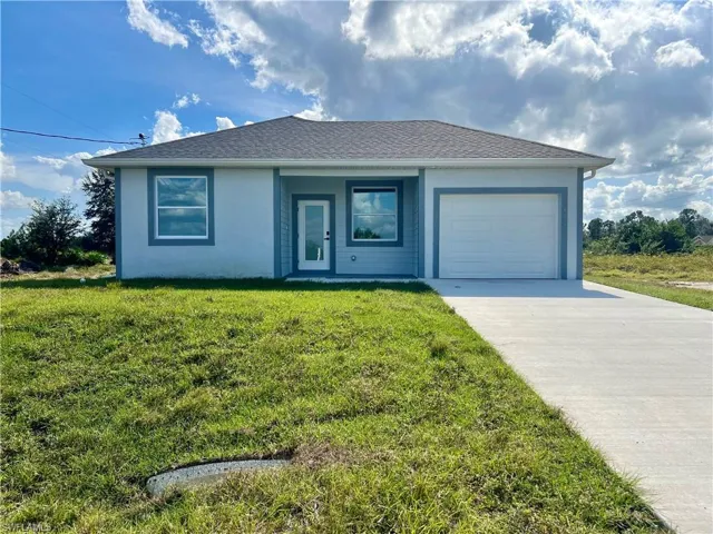Front of home featuring a garage and a front lawn