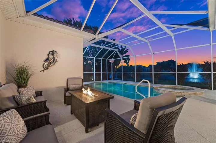 Pool at dusk featuring the additional comfortable and secluded outdoor seating area with a fire pit.