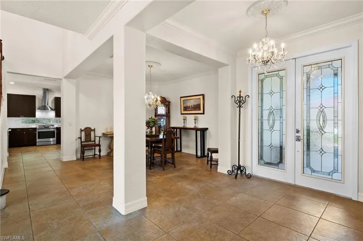 Beautiful entrance foyer showing the very decorative doors, the entry chandelier and crown molding.