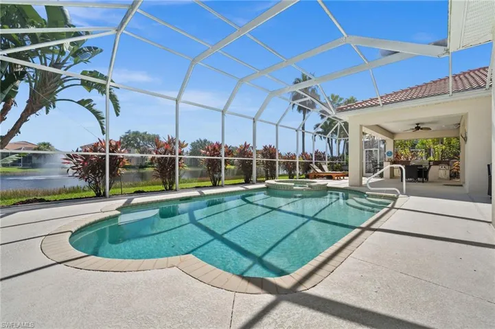 View of swimming pool featuring a patio area, an in ground hot tub, ceiling fan, and screen enclosure