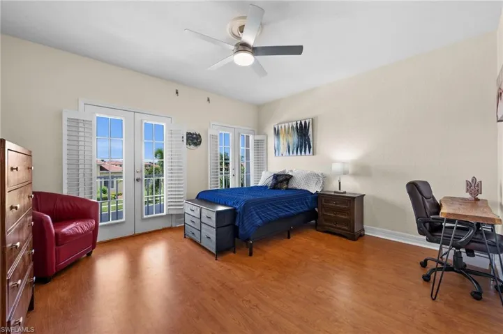 Bedroom with hardwood / wood-style flooring, access to outside, french doors, and ceiling fan