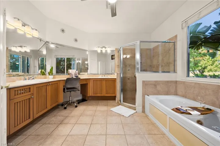 Bathroom featuring plenty of natural light, vanity, and tile patterned flooring