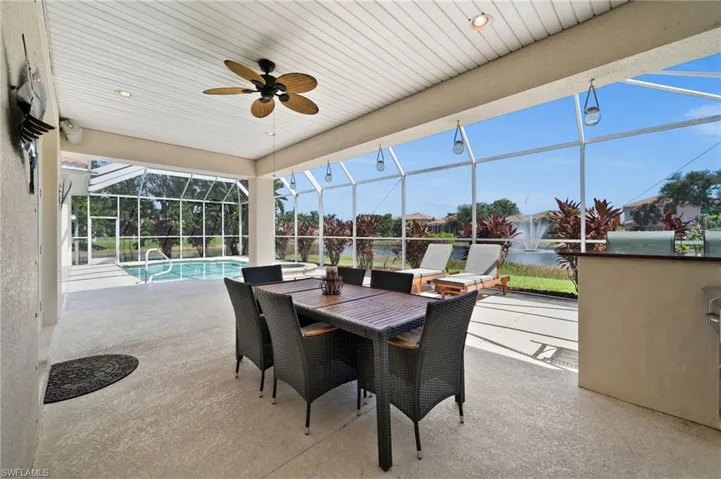 Here the daylight view of the beautiful outdoor seating area on the covered deck with large screened pool and SPA