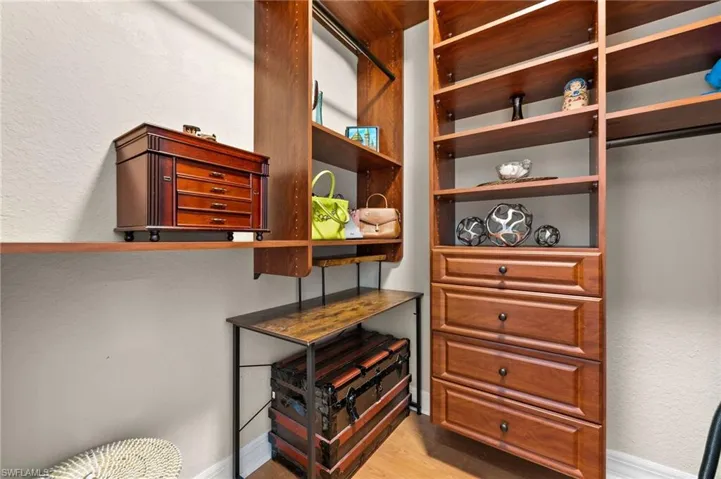 Spacious closet with light hardwood / wood-style flooring