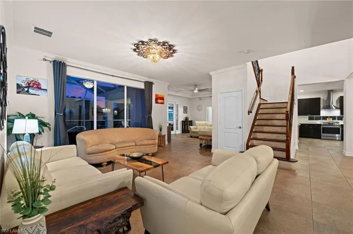Tiled living room with ornamental molding and ceiling fan